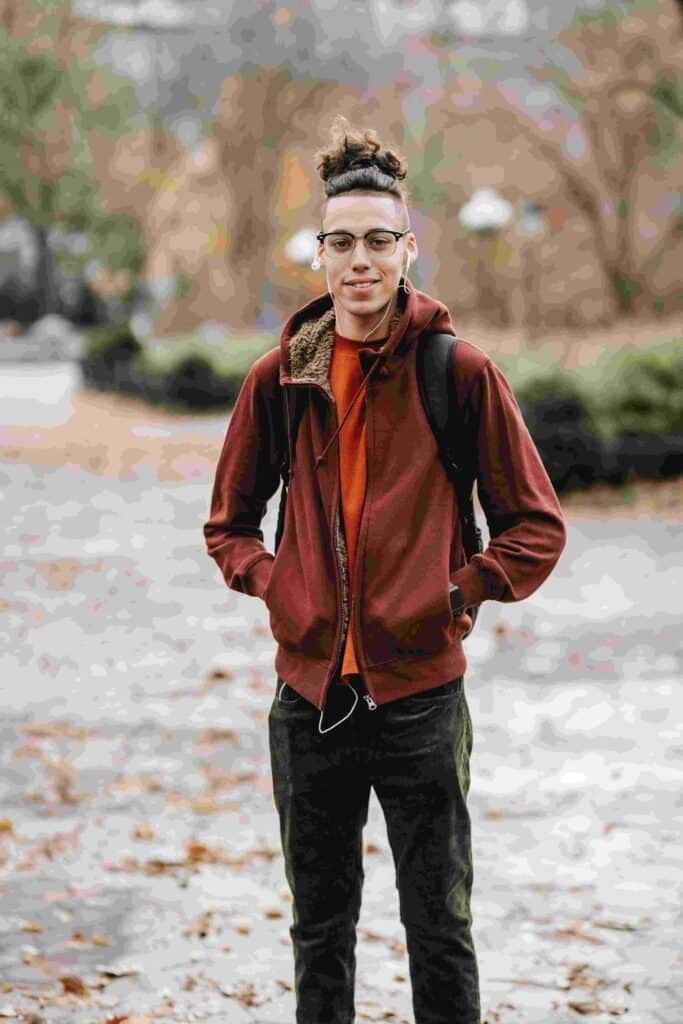 A skinny guy poses while smiling