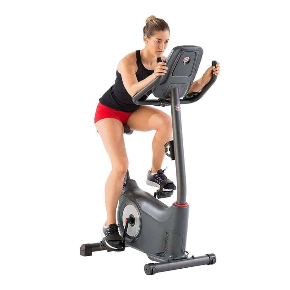 A lady riding the Schwinn 170 Upright Bike is being ridden by a lady