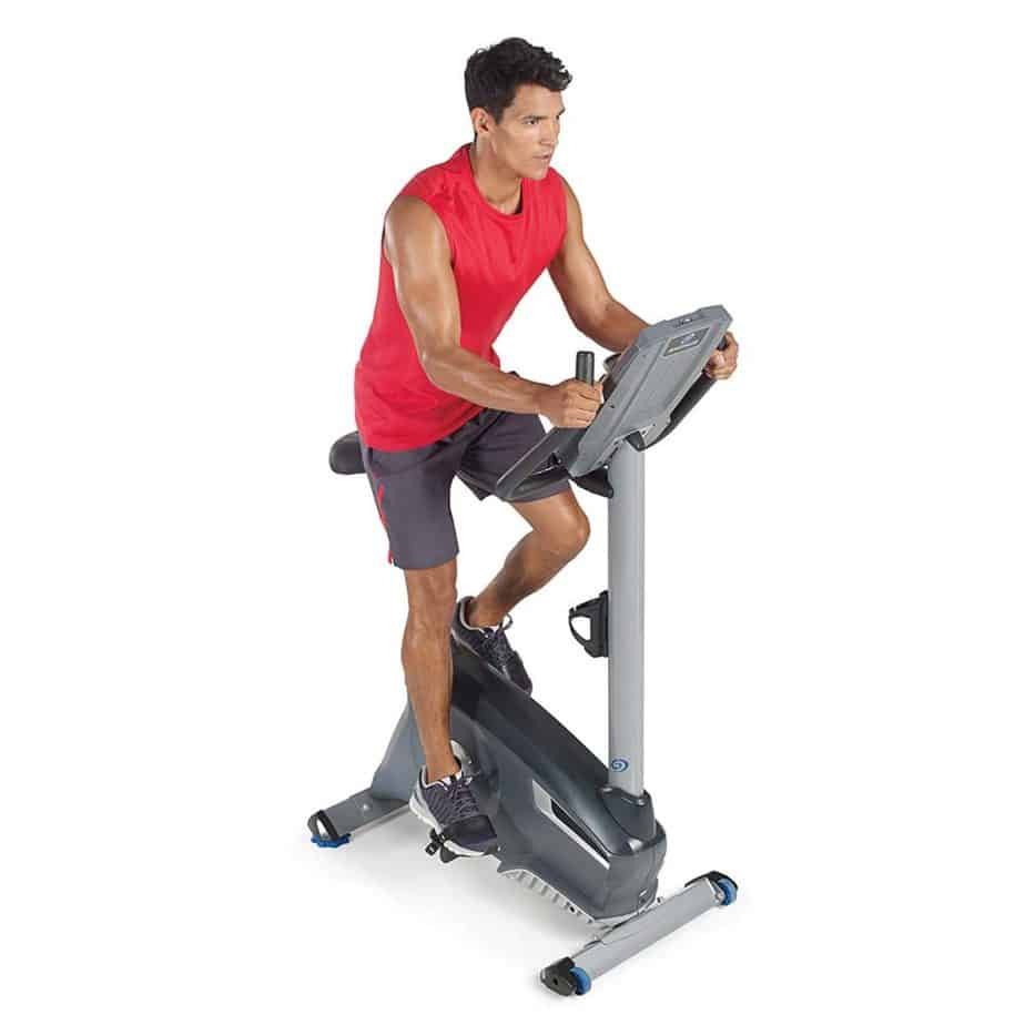 An athlete is exercising on the Nautilus U614 Upright Bike