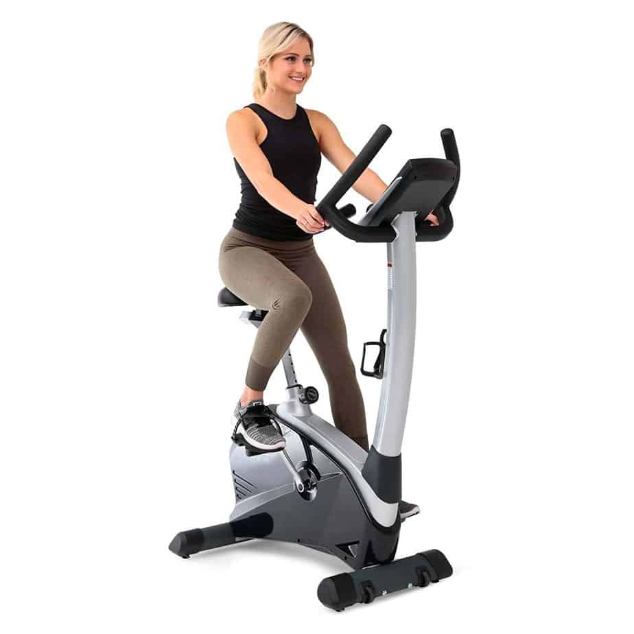A lady is exercising on the 3G Cardio Elite UB Upright Bike
