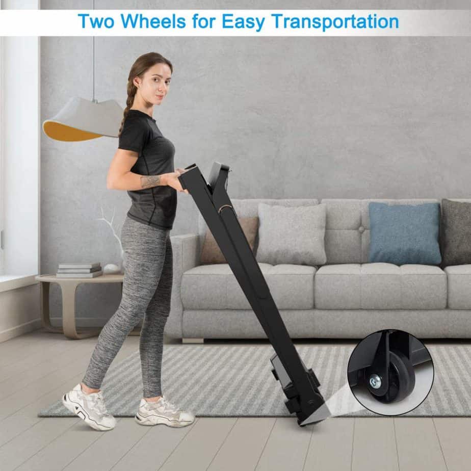 A lady is rolling the Goplus Electric Folding Treadmill  away to storage