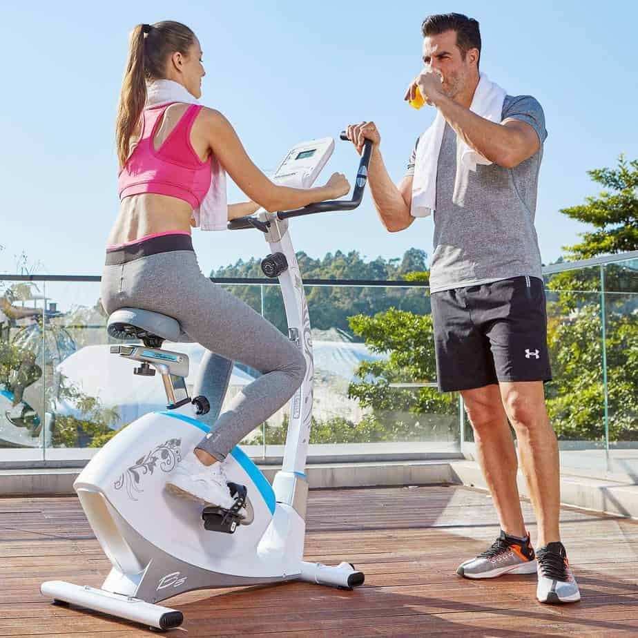A lady is working out with the HARISON B5 Upright Magnetic Bike