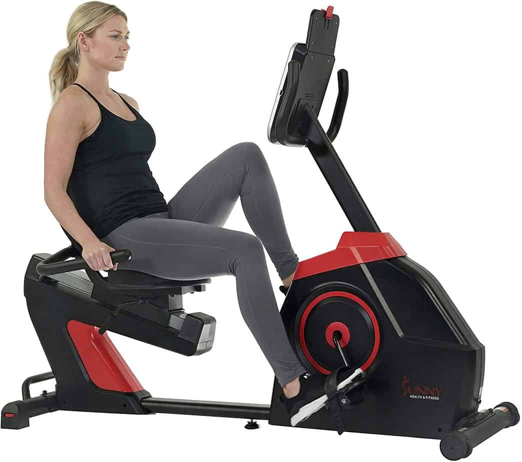A lady is exercising with the Sunny Health & Fitness SF-RB4954 Evo-Fit Cardio Recumbent Bike
