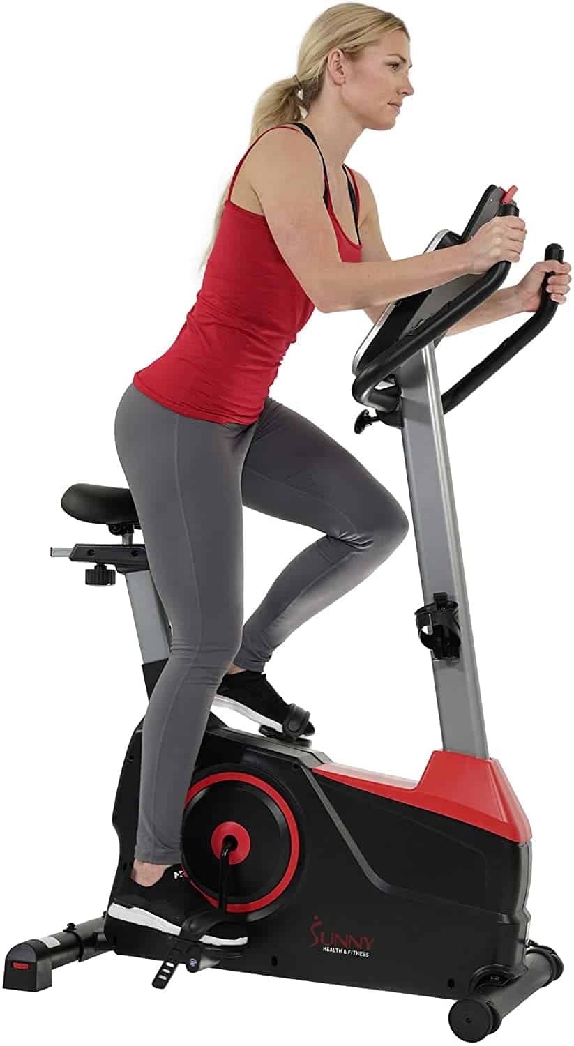 A lady is exercising with the Sunny Health & Fitness Evo Fit SF-B2969 Upright Bike