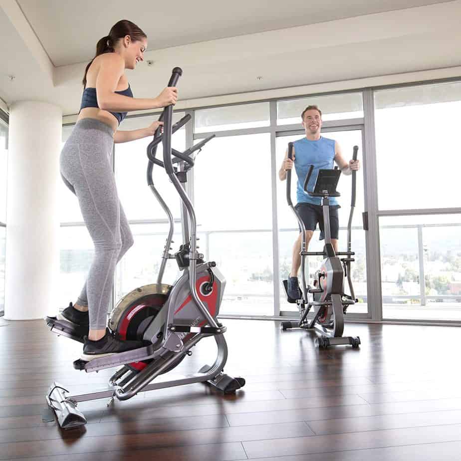 A lady and a gentle man are working out with the Body Power 2-in-1 BST800 Elliptical Stepper Trainer