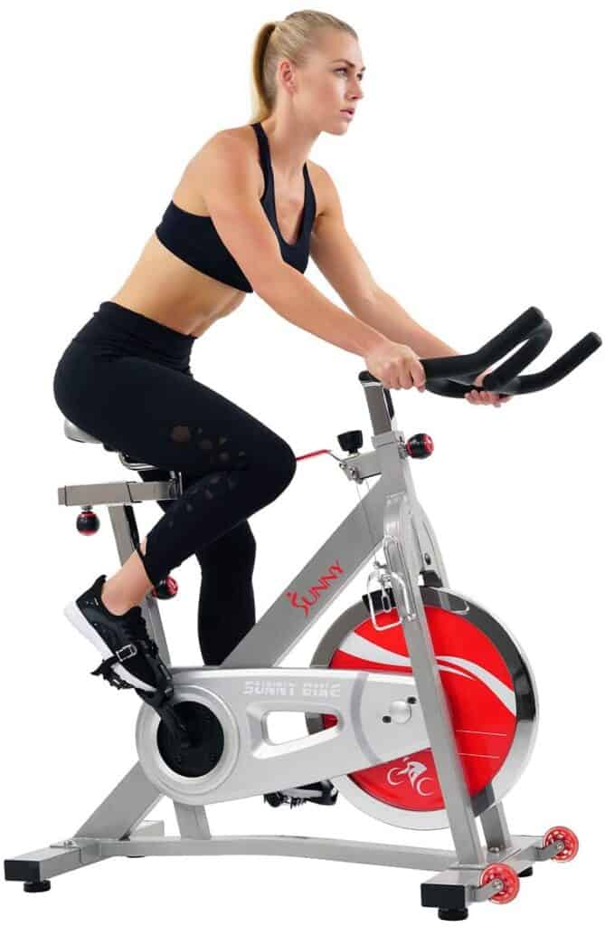 A lady rides the Sunny Health and Fitness Pro SF-B901B Indoor Cycling Bike 