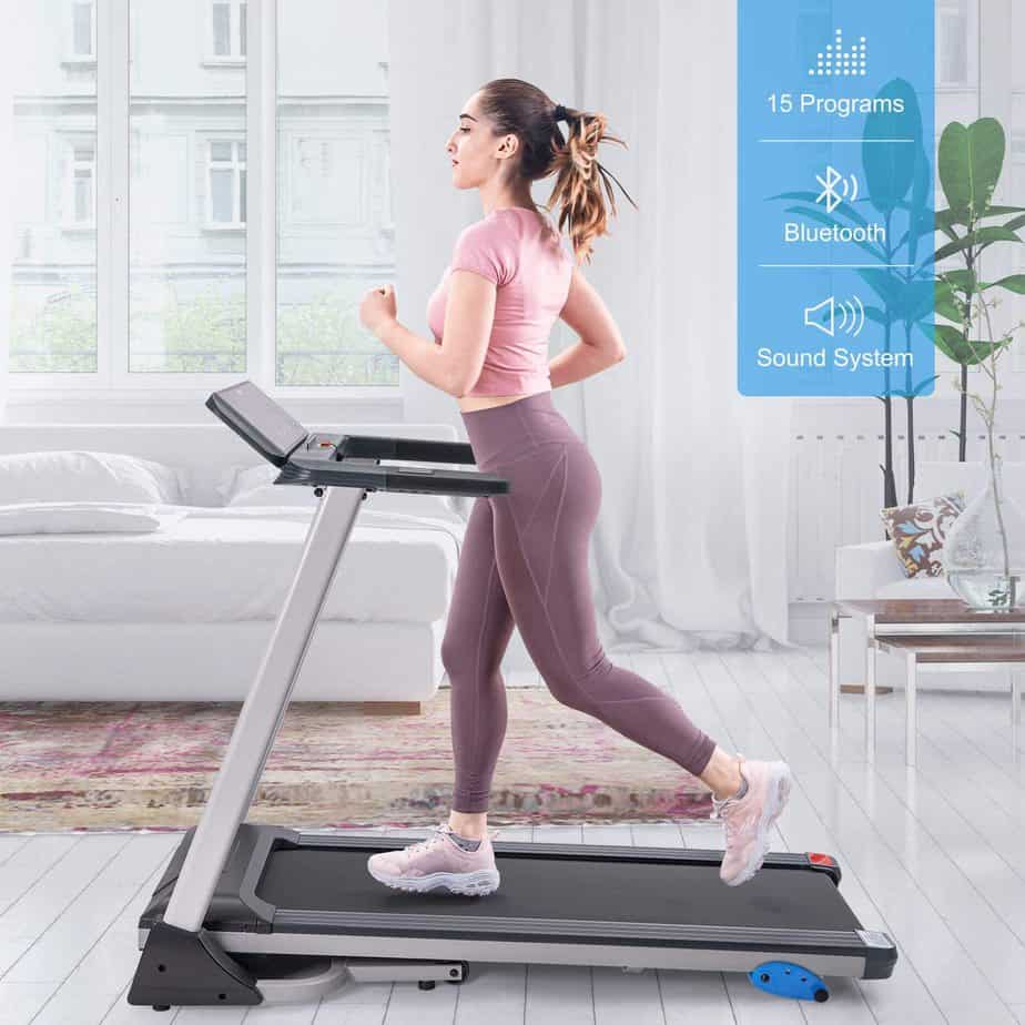A lady is jogging on the Merax Folding Electric Treadmill