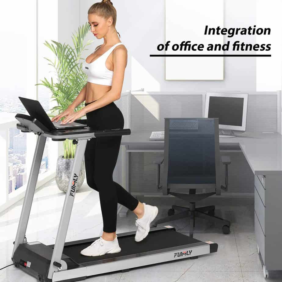 A lady works on a computer while working on out on theFUNMILY 2.25 HP Folding Treadmill