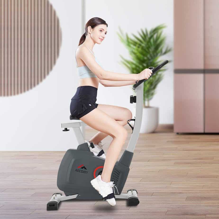 A lady exercises with the AECOJOY Upright Magnetic Exercise Bike