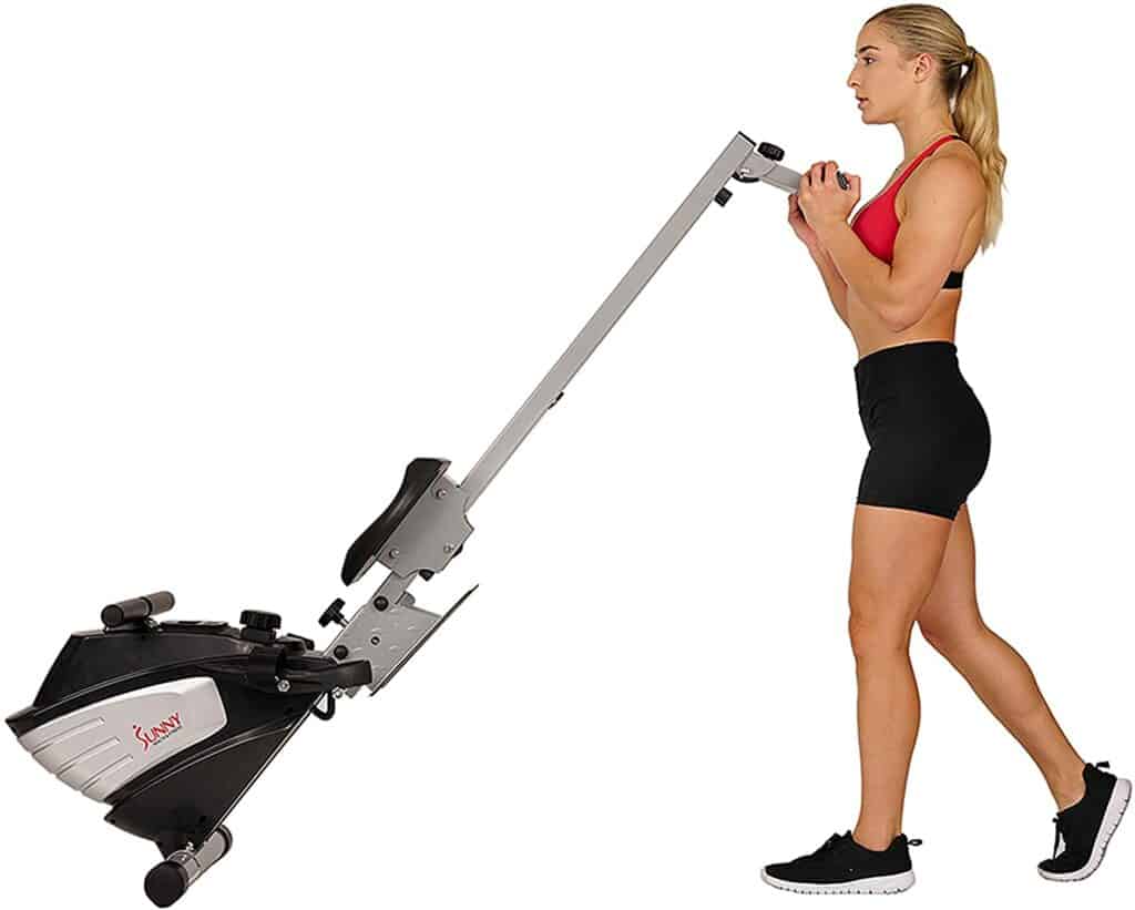 A lady moves the Sunny Health & Fitness SF-RW5622 Magnetic Rowing Machine for storage