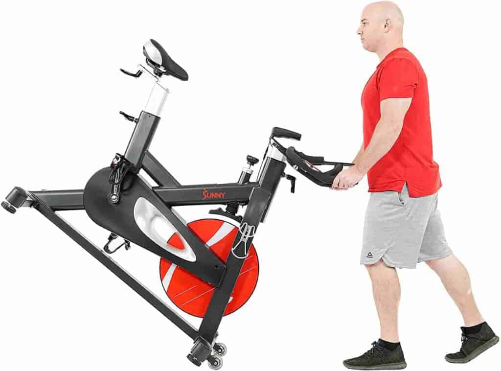 The  user rolls the Sunny Health & Fitness SF-B1986 Evolution Pro II Cycling Bike away for storage