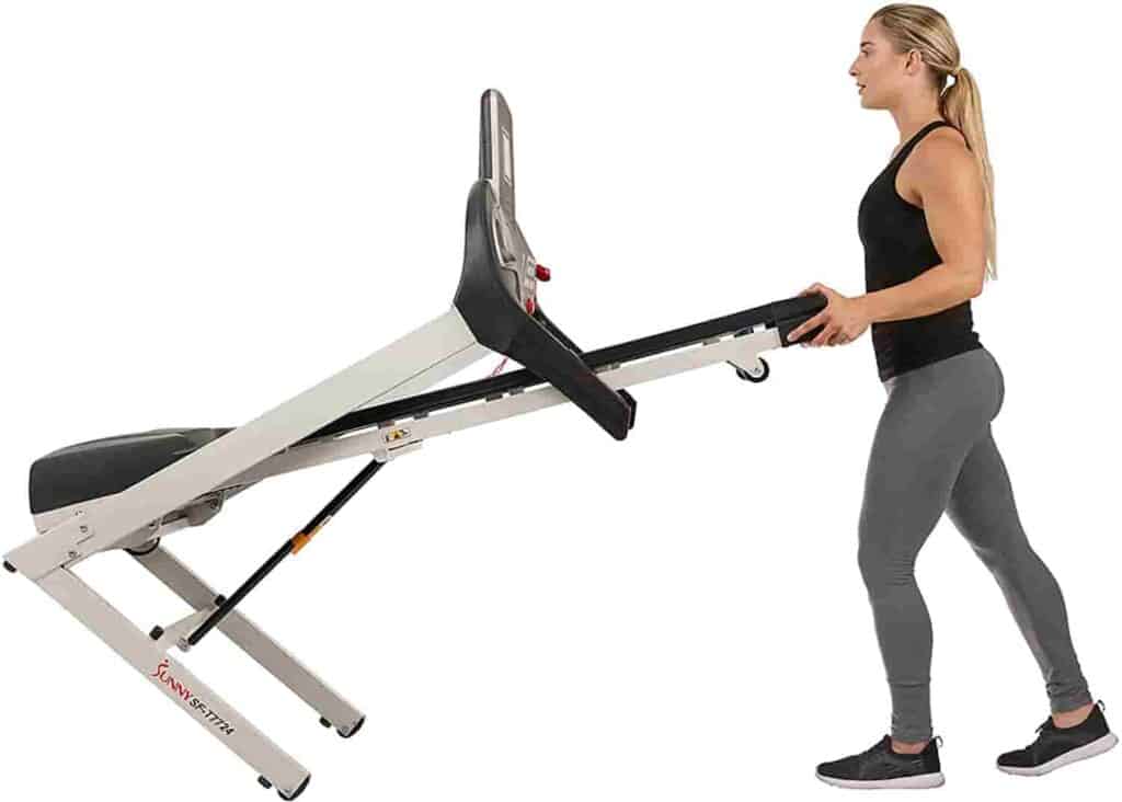 This lady moves the Sunny Health & Fitness Energy Flex SF-T7724 Treadmill to a storage area
