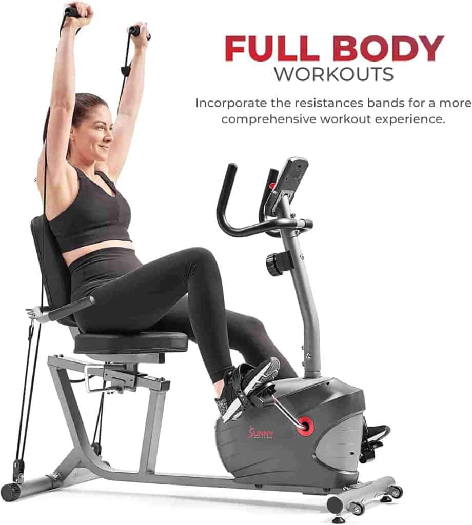 A lady exerrcises with the Sunny Health & Fitness Interactive SF-RB420031 Recumbent Bike and the resistance bands