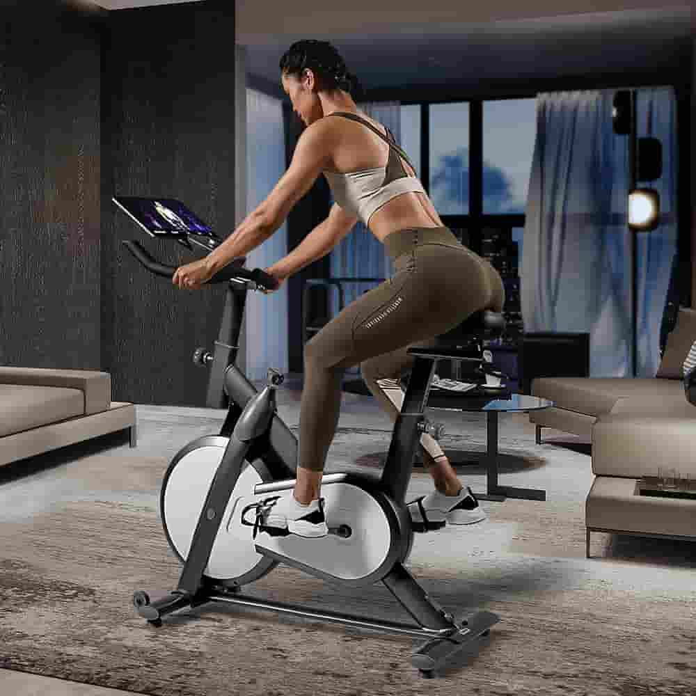 A lady rides the Mobifitness TURBO Indoor Magnetic Exercise Bike