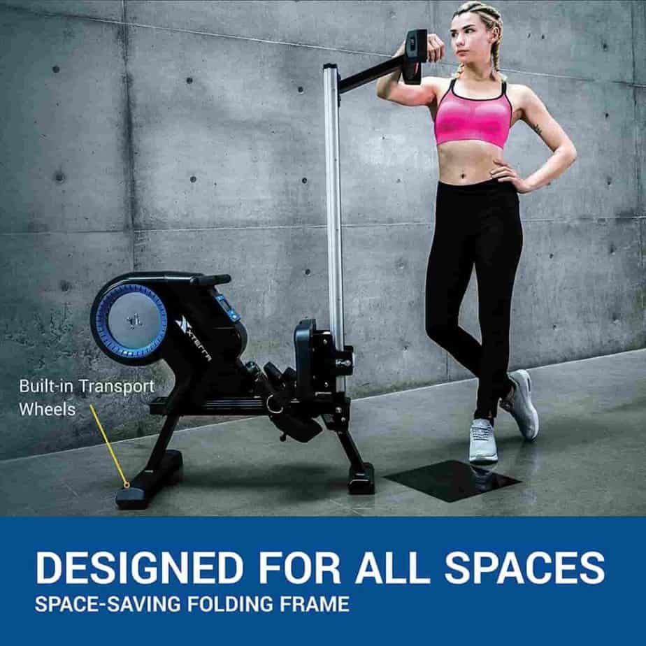 A lady poses by the folded XTERRA Fitness ERG220 Rower