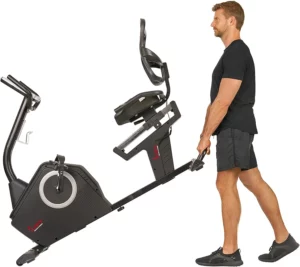 A man rolls the Sunny Health & Fitness SF-RB4850 Recumbent Bike away to the storage area